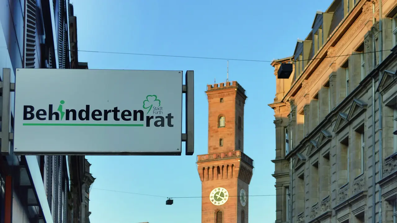 Behindertenrat Schild mit der Aufschrift „Behindertenrat“, im Hintergund das Fürther Rathaus