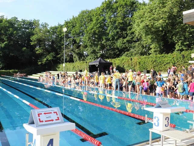Schwimmbecken und Teilnehmende beim Schultriathlon Klick öffnet die Meldung.