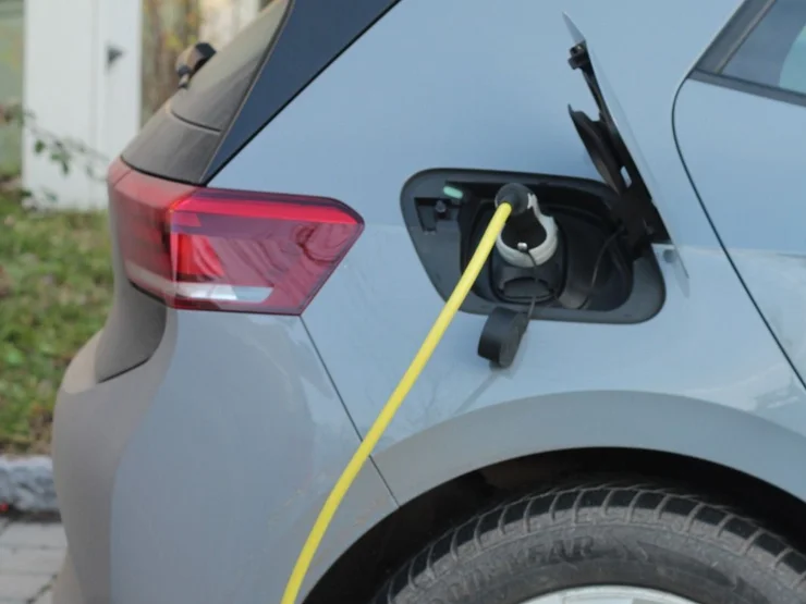 Graues Auto während des Ladevorgangs an einer Ladesäule. 