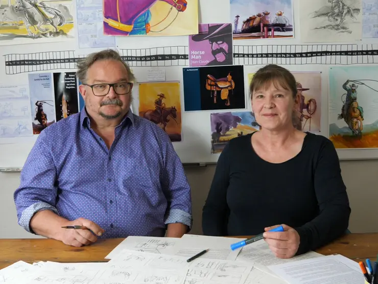 Illustratorin Petra Herberger und Autor Jochen Findeiss vor ihrem Moodboard mit Studien und Zeichnungen zur Graphic Novel "Horse Man Jean-Claude Dysli. Ein schweizer Cowboy in den USA"