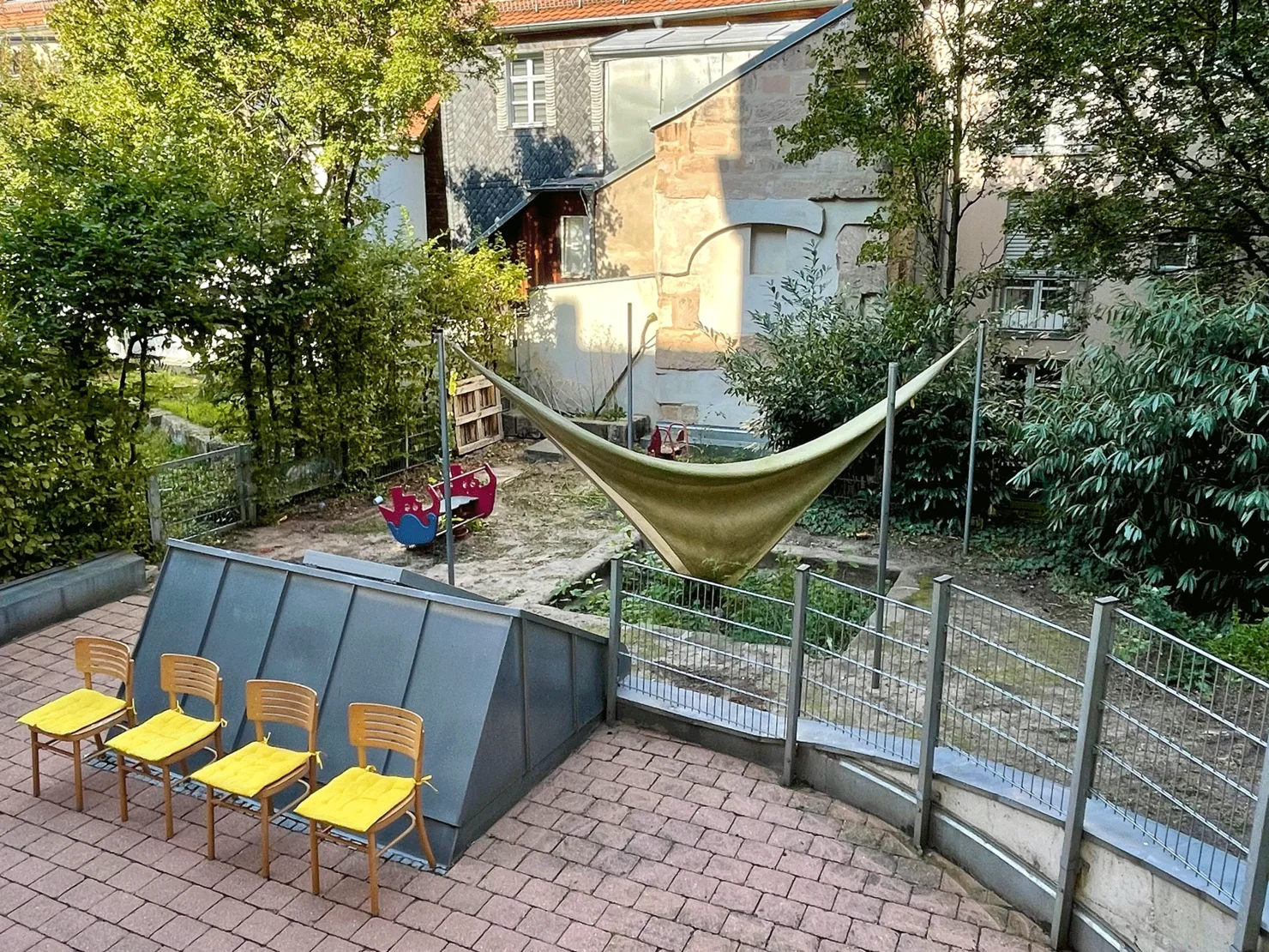 Blick in den Innenhof mit Stühlen und Spielgeräten