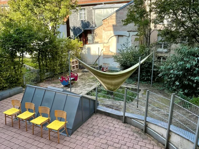 Blick in den Innenhof mit Stühlen und Spielgeräten