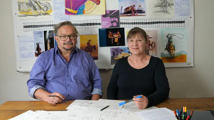 Illustratorin Petra Herberger und Autor Jochen Findeiss vor ihrem Moodboard mit Studien und Zeichnungen zur Graphic Novel "Horse Man Jean-Claude Dysli. Ein schweizer Cowboy in den USA"