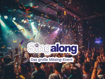 Menschenmenge bei einem Konzert mit buntem Konfetti und Bühnenbeleuchtung im Hintergrund