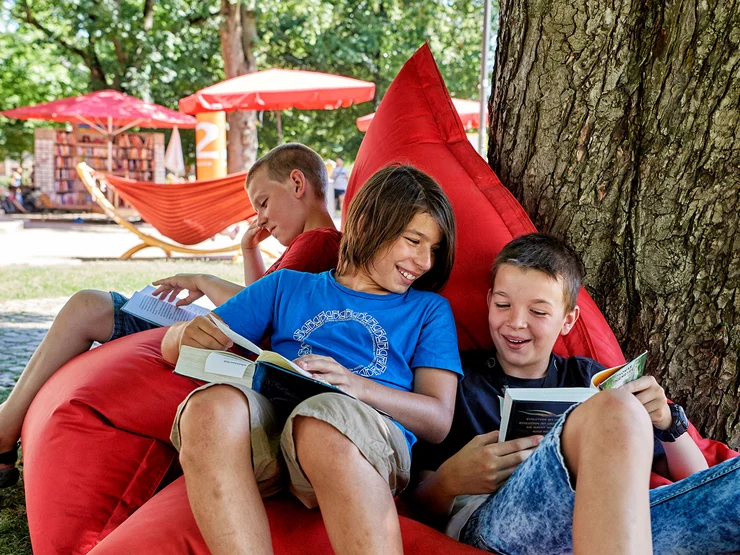 Jugendliche lesen in der Konrad-Adenauer-Anlage in einem Sitzsack.