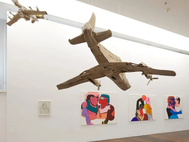 Blick in den Ausstellungsraum mit Bildern und Objekten.