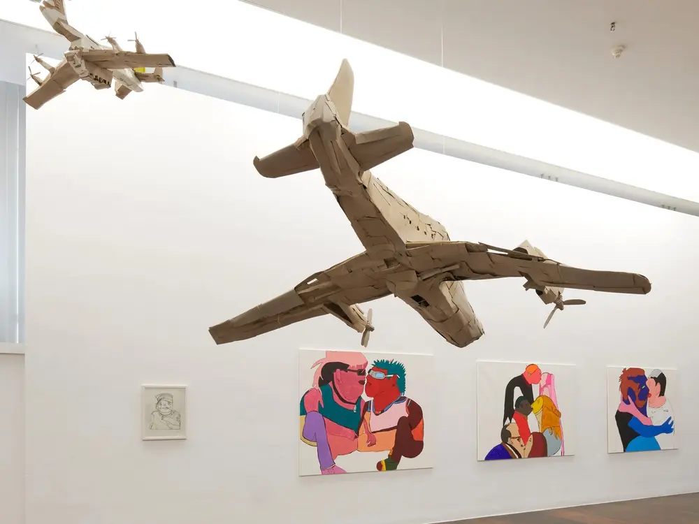 Blick in den Ausstellungsraum mit Bildern und Objekten.