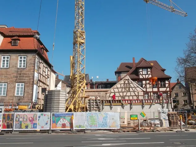 Ein Bauzaun wurde mit großformatiger Kinderkunst dekoriert.