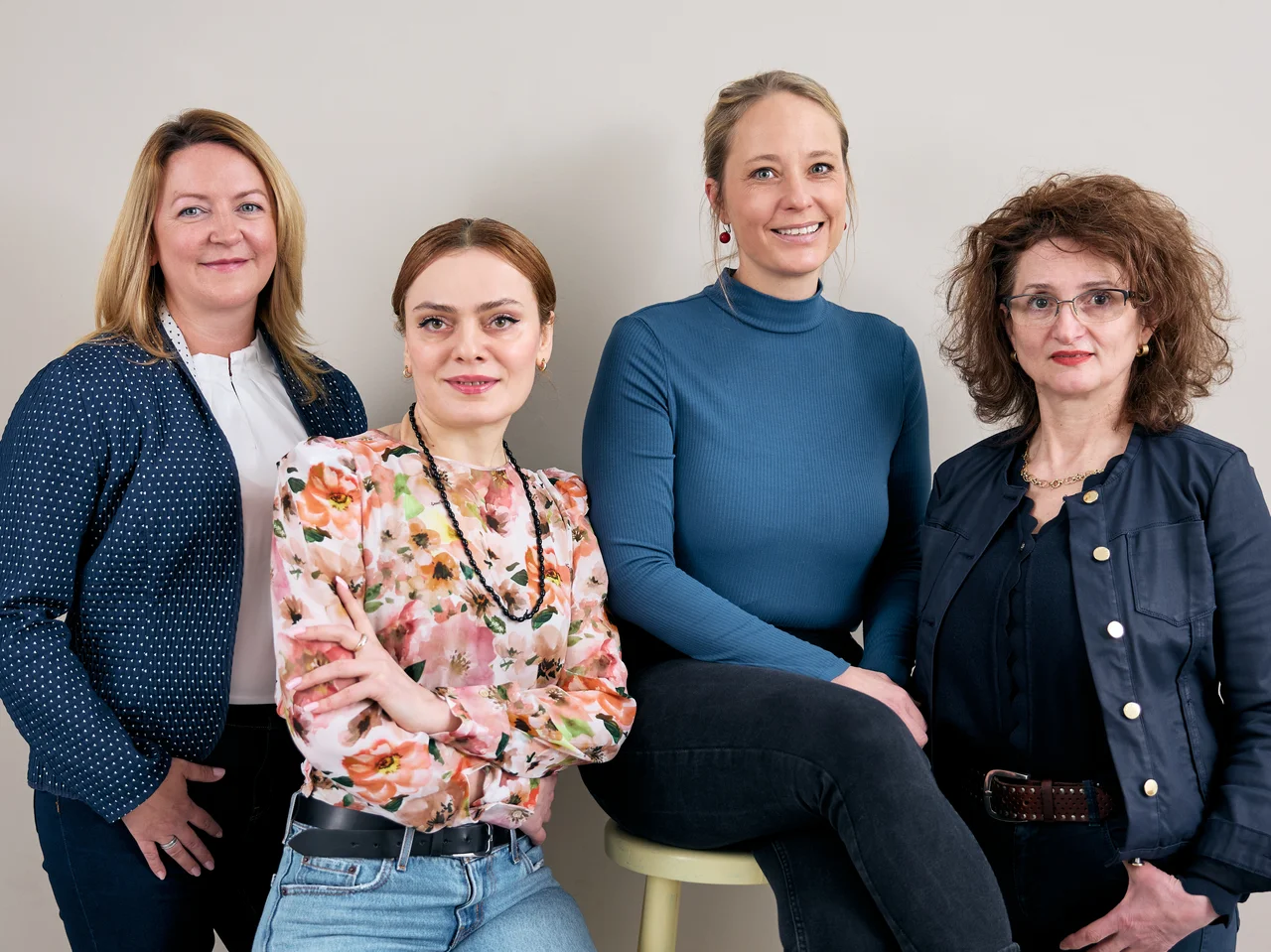 Die vier Mitarbeiterinnen stehen im Rahmen eines Shootings nebeneinander und blicken in die Kamera. 