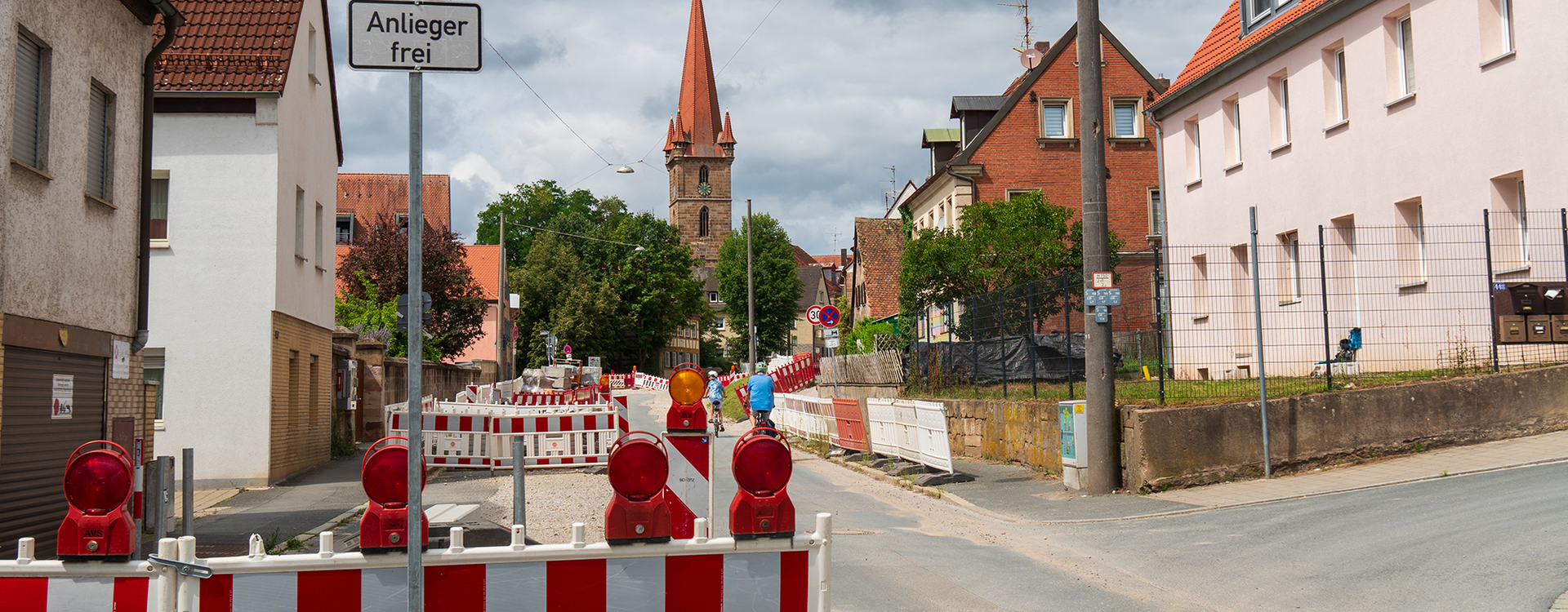 Baustelle Burgfarrnbach 2024 Die Baustelle mit Absperrungen und dem Kirchturm im Hintergrund.