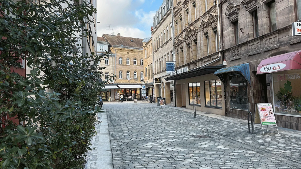 Blick auf die neugestaltete Moststraße mit Pflaster und begrünten Fassaden.