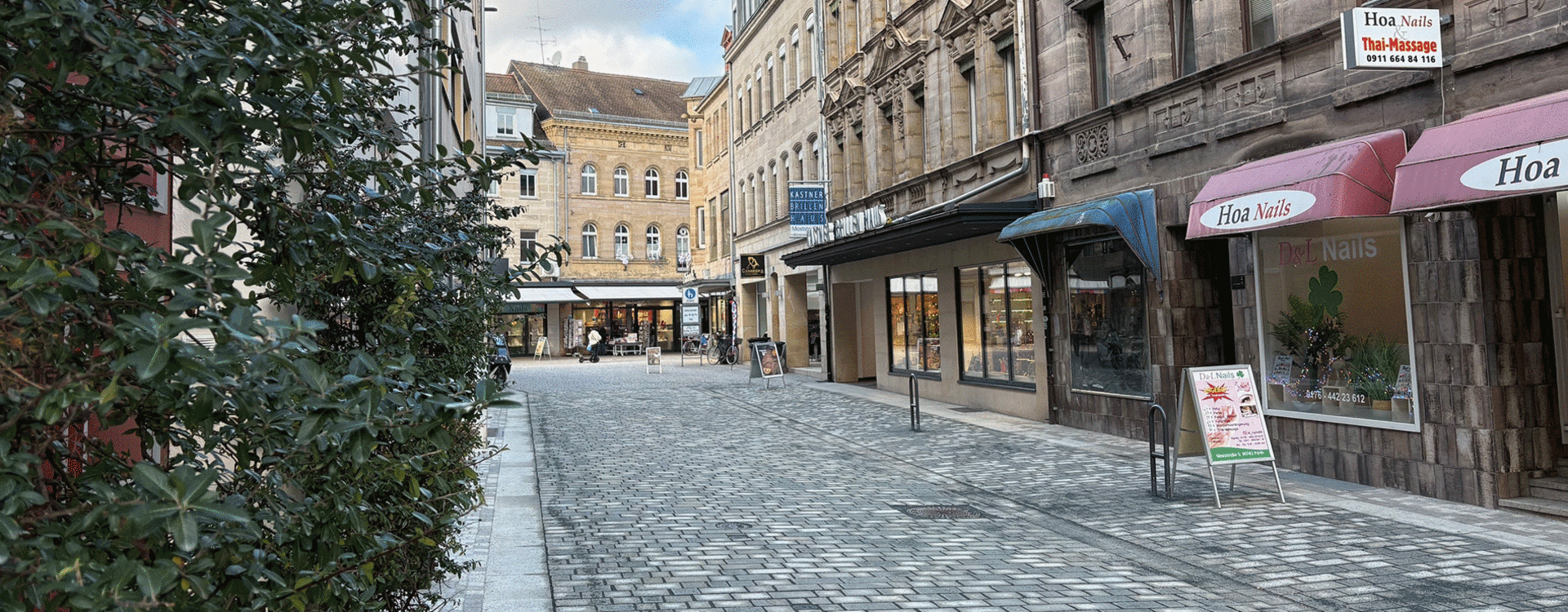 Blick auf die neugestaltete Moststraße mit Pflaster und begrünten Fassaden.