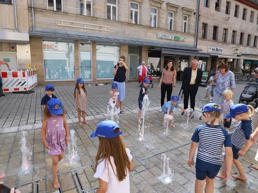 Kinder spielen mit den Fontänen des neuen Brunnens in der Fußgängerzone. Klick öffnet Bild in größerer Ansicht.. 