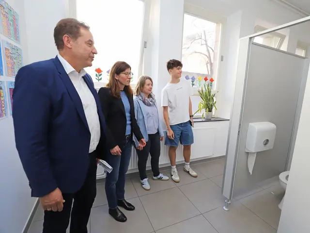 Personen in der sanierten Sanitäranlage; Klick zeigt Bild in größerer Darstellung.