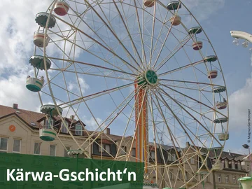 Riesenrad der Fürther Michaeliskirchweih auf der Fürther Freiheit, davor der Schriftzug "Kärwa-Gschicht'n".
