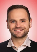 Porträtaufnahme des Stadtrats vor weiß-rotem Hintergrund