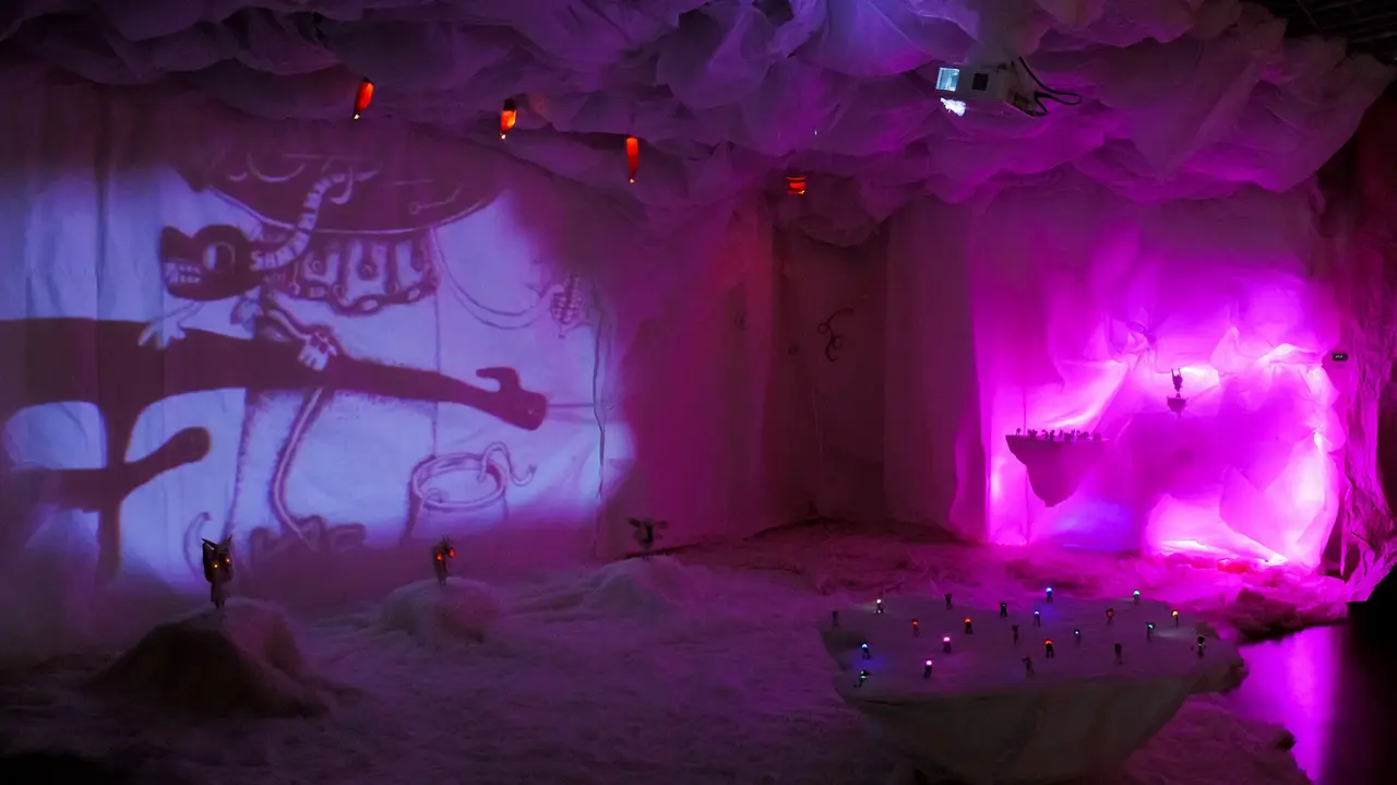 Violett illuminierte Installation einer vorzeitlichen Höhle