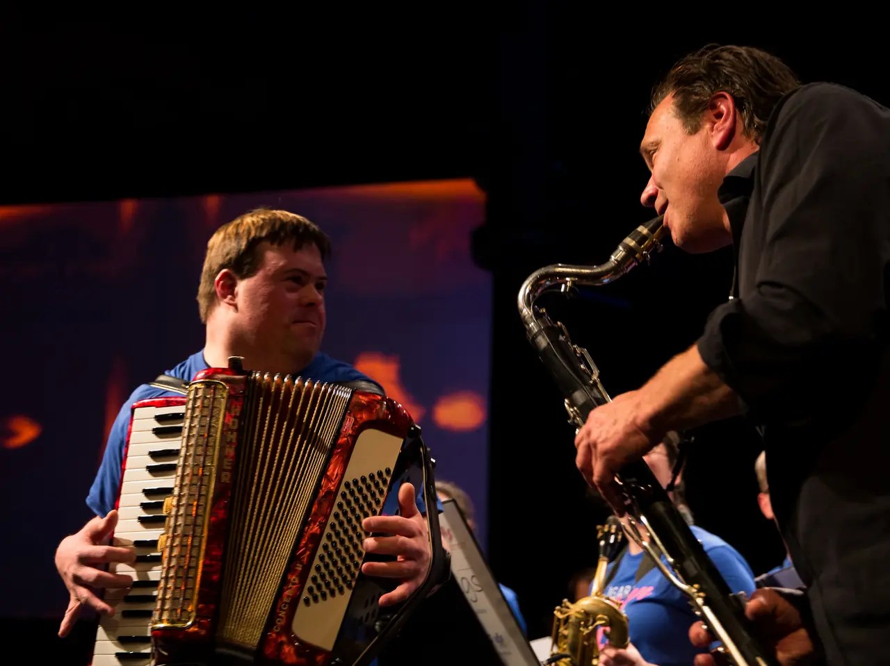 Akkordeonspieler und Saxophonist schauen sich auf Bühne an. Klick öffnet Bild in größerer Ansicht.