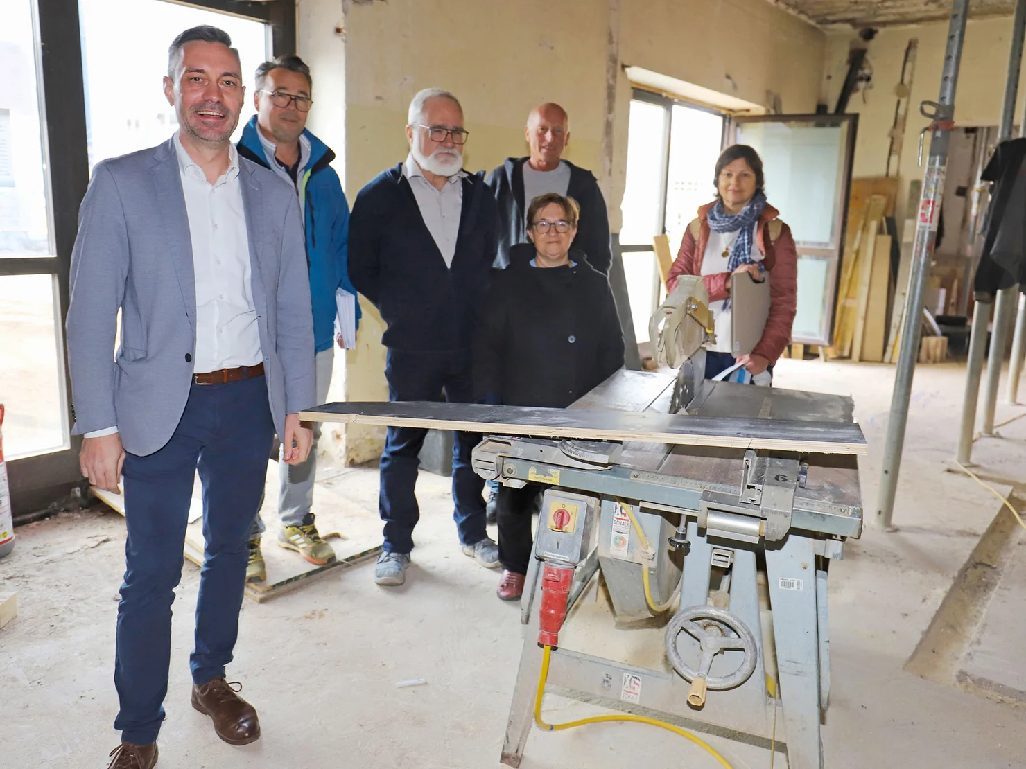 Döhla, Lerotic, Neubarth, Christoph, Heinzler und Thürauf im Inneren des Rohbaus neben einer Werkbank.