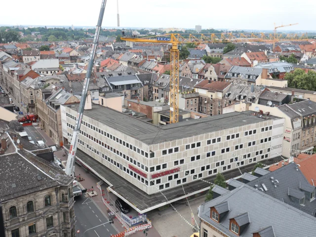 Bild von oben auf das Gebäude. Im Innenhof ist ein gelber Baukran. Klick öffnet die Meldung.