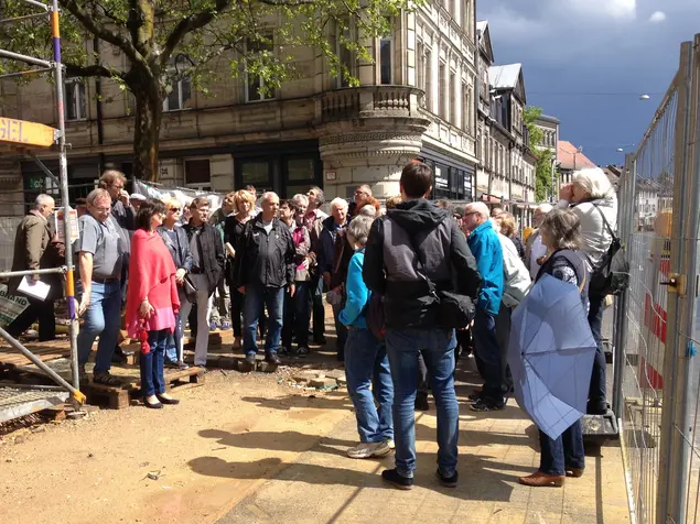 Eine Gruppe menschen bei einer Führung vor der Baustelle des Erweiterungsbaus Jüdisches Museum