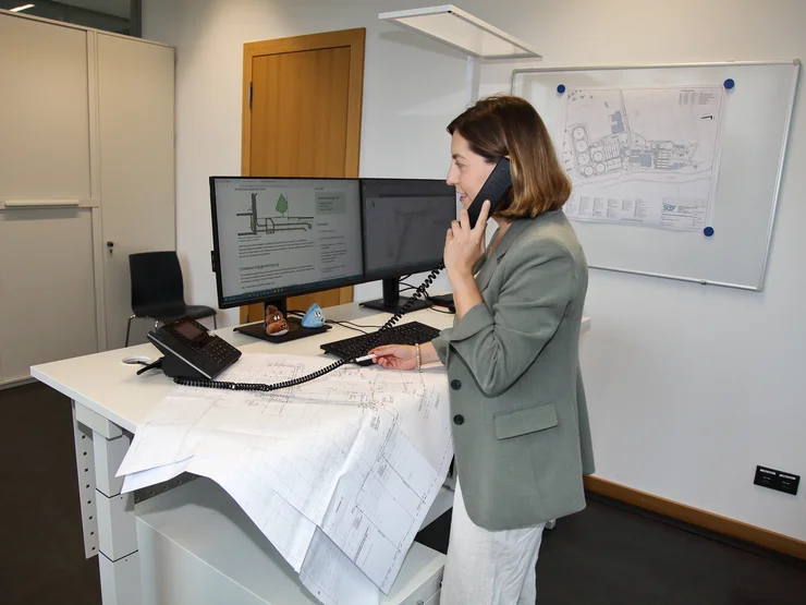 Eine Büromitarbeiterin telefoniert am Schreibtisch. 