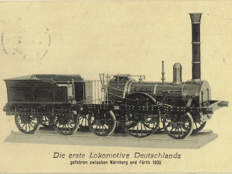 Schwarz-weiße Abbildung der ersten deutschen Lokomotive "Der Adler", seitliche Ansicht, darunter Text mit Baujahr 1835 und Einsatzort Nürnberg-Fürth.