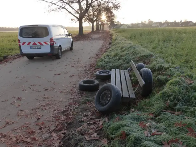 Autoreifen an einer Parkband in einer Allee abgelegt, daneben PKW des Ordnungsdamts