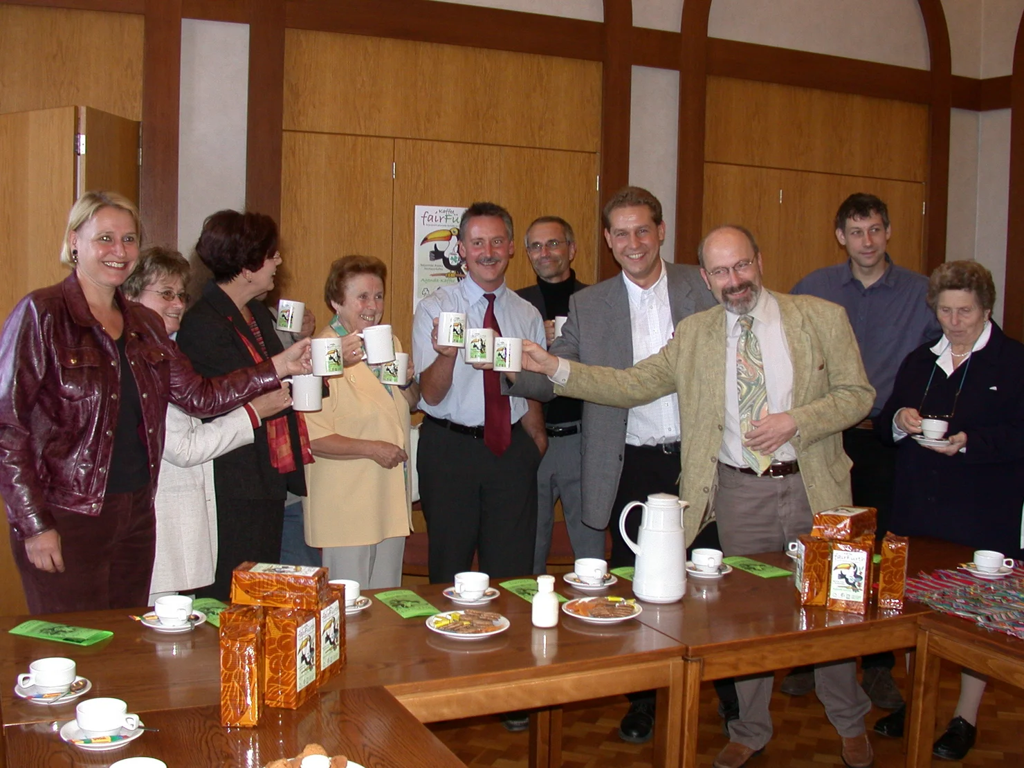 Teilnehmende des Pressetermins stoßen mit Fairtrade Kaffee an. Klick öffnet Bild in größerer Ansicht..