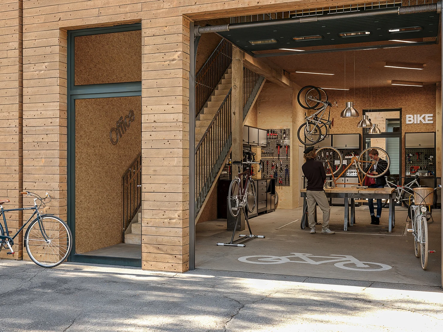 Illustration einer Halle, in der eine Fahrradwerkstatt untergebracht ist. 