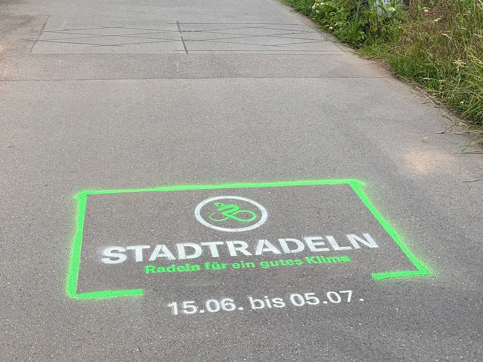 Radweg mit aufgespraytem Logo mit der Aufschrift "Stadtradeln. Radeln für ein gutes Klima. 15.6. bis 5.7."