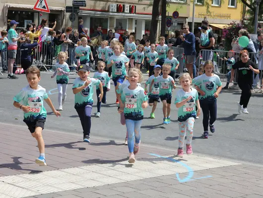 Laufende Kinder und Zuschauende beim Kidsmarathon; Klick öffnet Detailansicht.