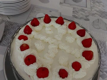 Runde Torte mit weißer Sahne und Erdbeeren als Dekoration auf einem Tisch