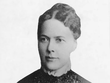 Schwarz-weiß-Porträt von Emilie Lehmus mit hochgestecktem Haar und einem Kleid mit floraler Spitze am Oberteil.