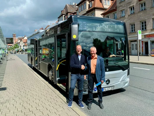 Steurer und Jung stehen vor einem Linienbus. Klick öffnet die Meldung.