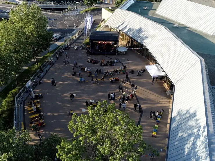 Personen feiern auf der Uferterrasse. Klick öffnet Veranstaltungstipp. 