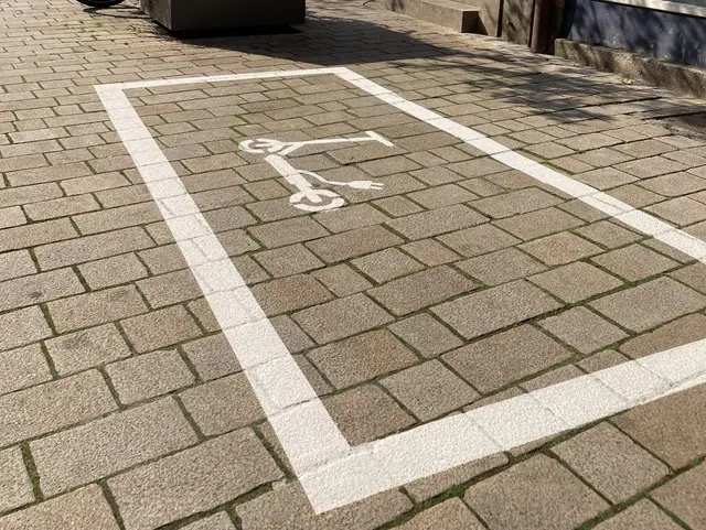 Weiße Bodenmarkierung mit einem weißen E-Scooter-Piktogramm. Klick öffnet die Meldung.