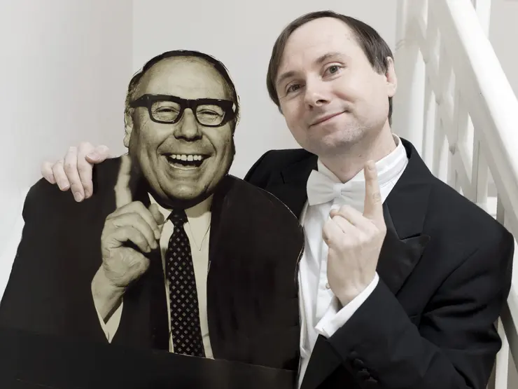Christoph Ackermann mit einem Pappaufsteller von Heinz Erhardt. Beide heben den scherzhaft den Zeigefinger.