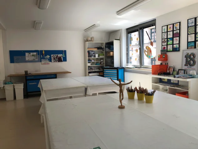 Große Tische im Werkraum bieten viel Platz. In den Regalen verschiedene Materialien.
