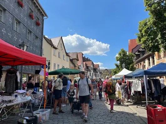 Menschen flanieren auf dem Grafflmarkt; Klick öffnet Detailansicht.