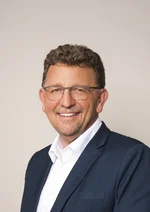 Porträtaufnahme des Stadtrats vor hellbraunem Hintergrund
