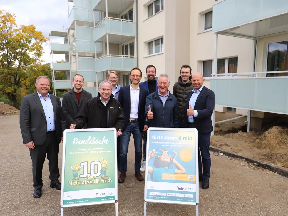 Gruppenfoto der beteiligten Personen vor dem Gebäude der Volkswohl. 