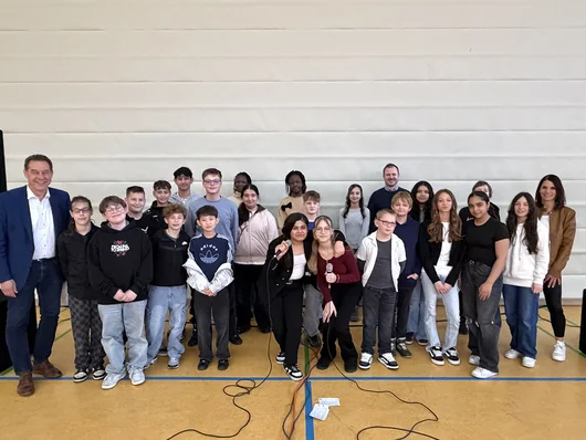 Gruppenfoto der Gewinnerklasse mit Bürgermeister Markus Braun in der Turnhalle der Schule. Klick öffnet die Meldung.