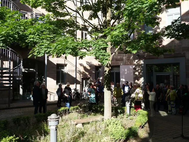 Eine Gruppe Menschen besichtigt einen Innenhof in der Fürther Innenstadt.