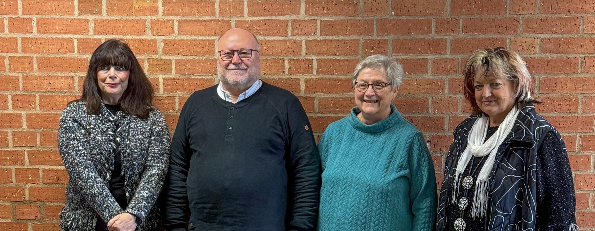 Genannte Personen vor Steindwand