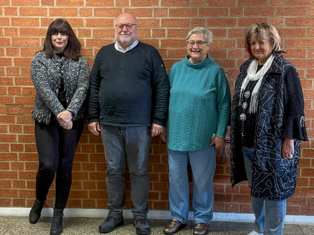 Genannte Personen vor Steindwand