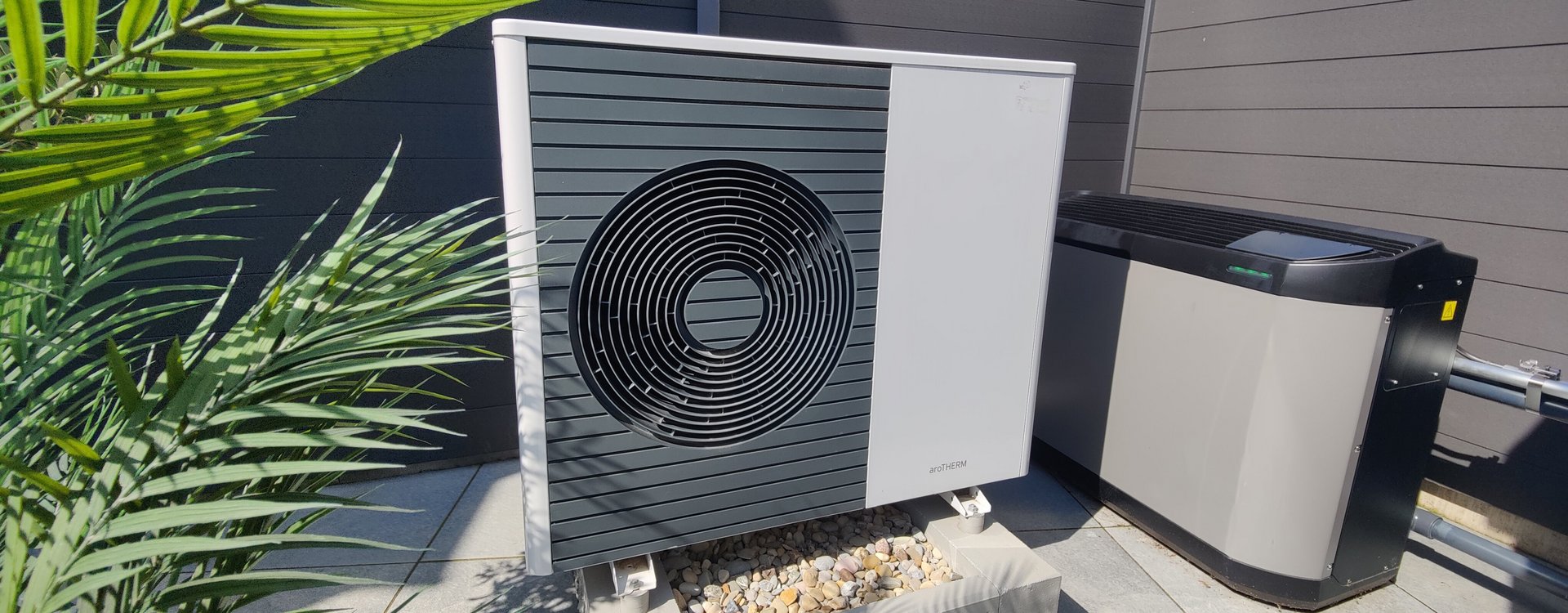 Wärmepumpe Wärmepumpe in einem Garten umringt von Grün