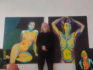 Der Künstler Richard Bartsch im Atelier vor zwei Aktgemälden