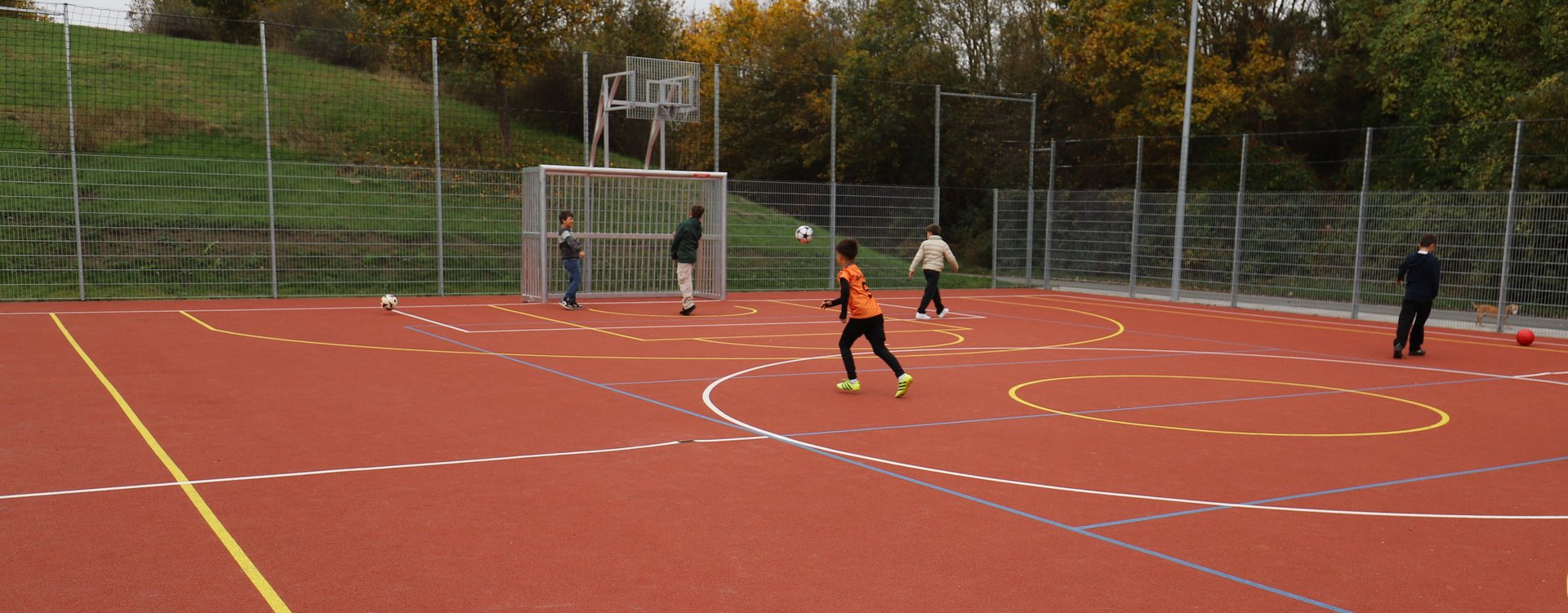 Allwetterplatz Jabob-Wassermann-Straße Auf dem neuen, barrierefreien Multifunktionsplatz mit Kunststoffbelag spielen Kinder.