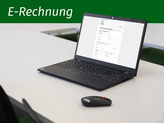 Schriftgrafik mit Text "E-Rechnung" und ein aufgeplapptes Notebooks. Klick öffnet Detailansicht des Artikels.